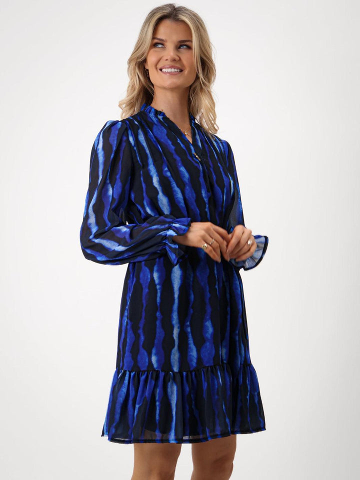 Woman wearing a blue patterned dress on a white background