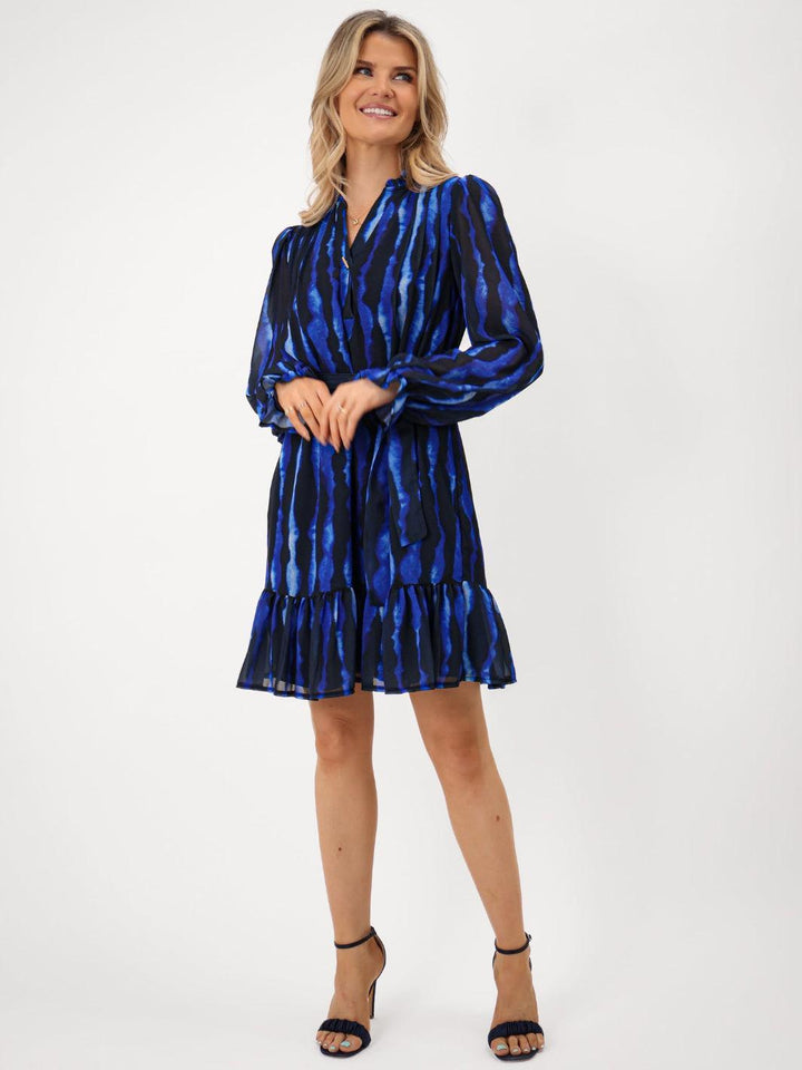 Woman wearing a blue tie-dye dress on a white background