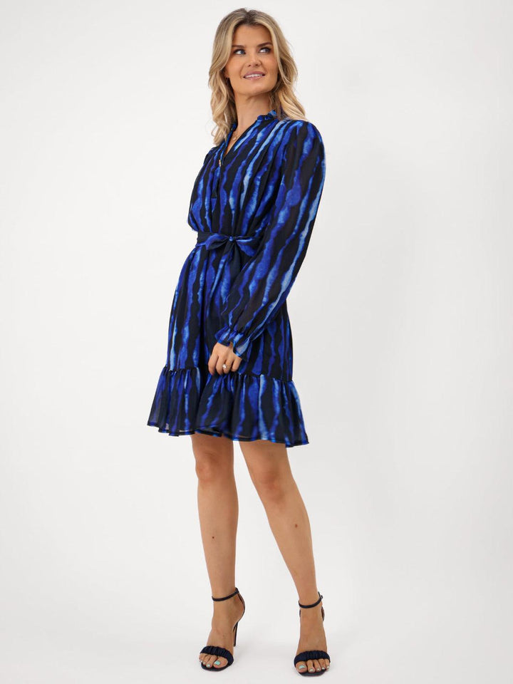 Woman wearing a blue patterned dress on a white background