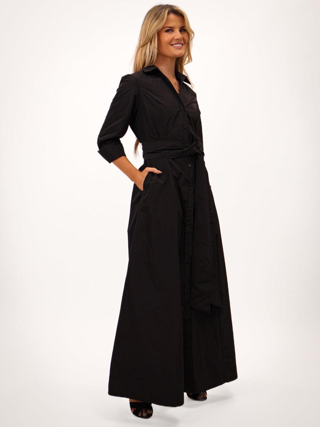 Woman wearing a black dress with a belt on a white background