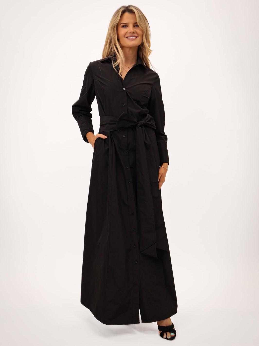 Woman wearing a black long-sleeve dress on a white background
