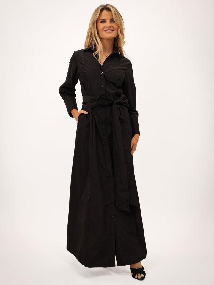 Woman wearing a black long-sleeve dress on a white background