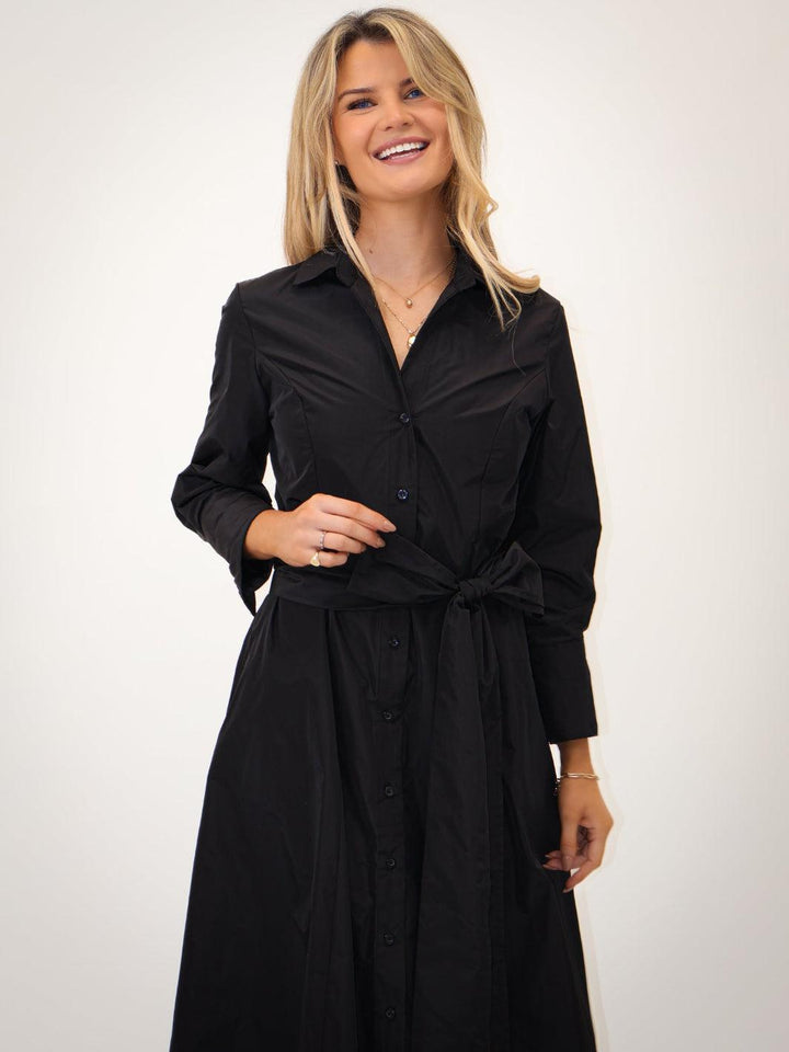 Woman wearing a black dress with a white background