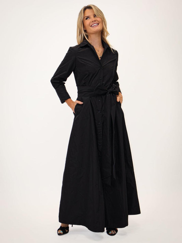 Woman wearing a black dress with a belt on a white background