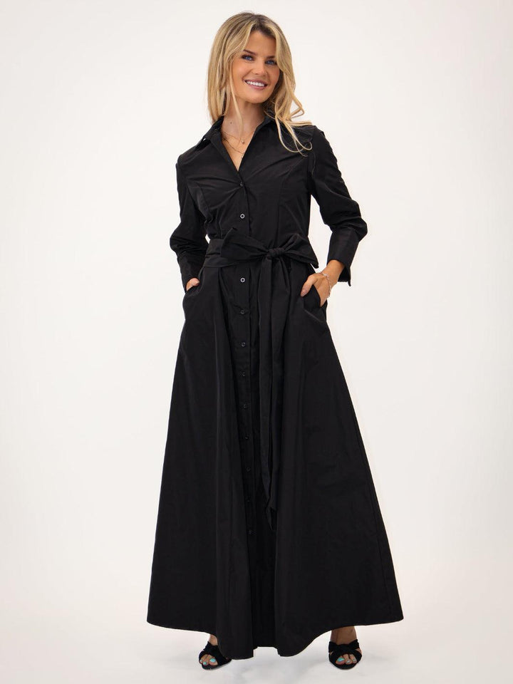 Woman wearing a black trench coat on a white background