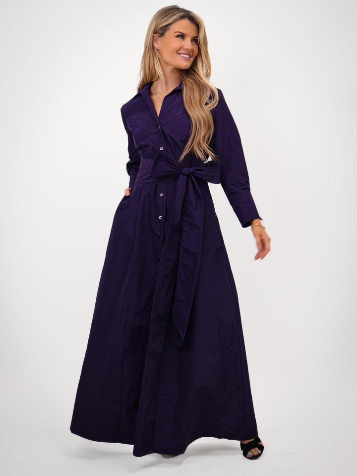 Woman wearing a long purple dress on a white background