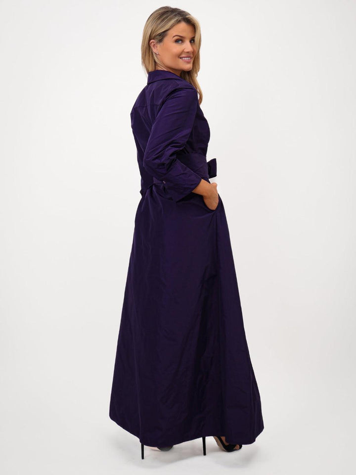 Woman wearing a long purple dress on a white background