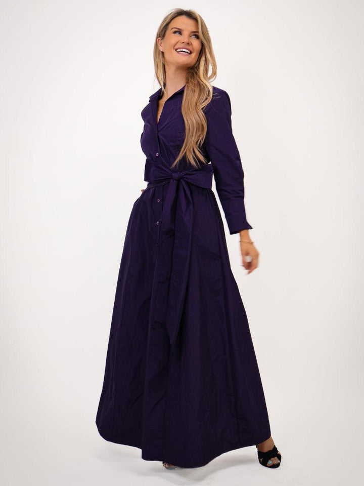 Woman wearing a long purple dress on a white background