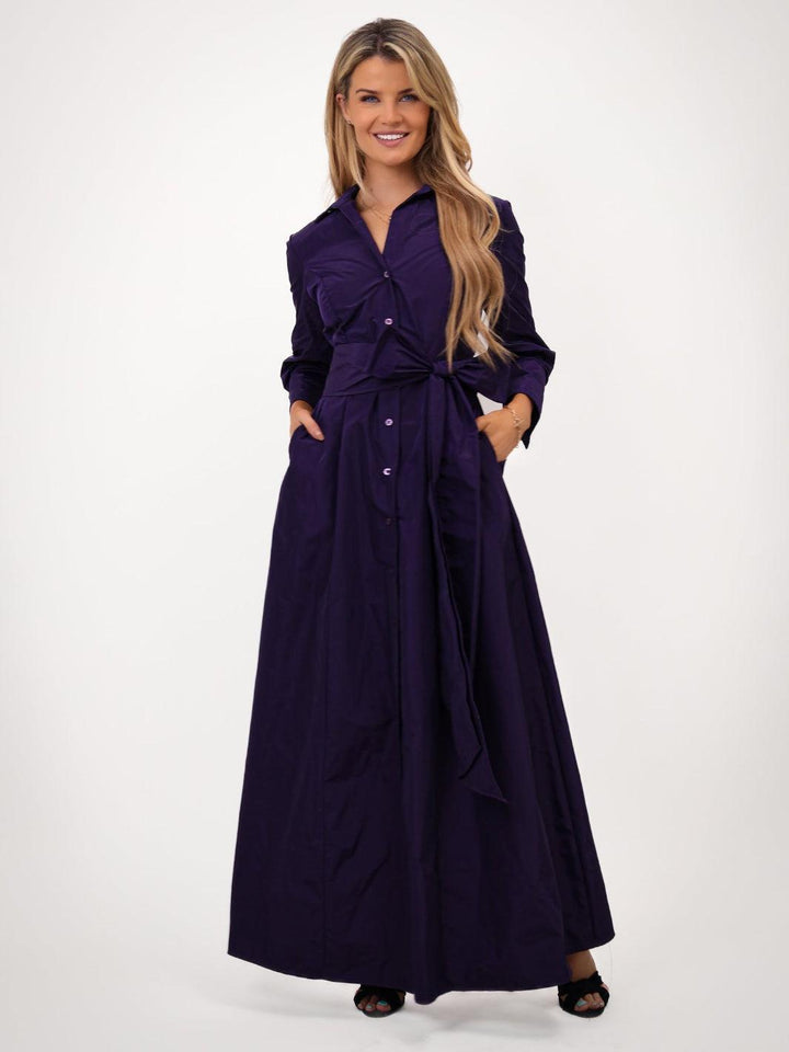 Woman wearing a long purple dress on a white background