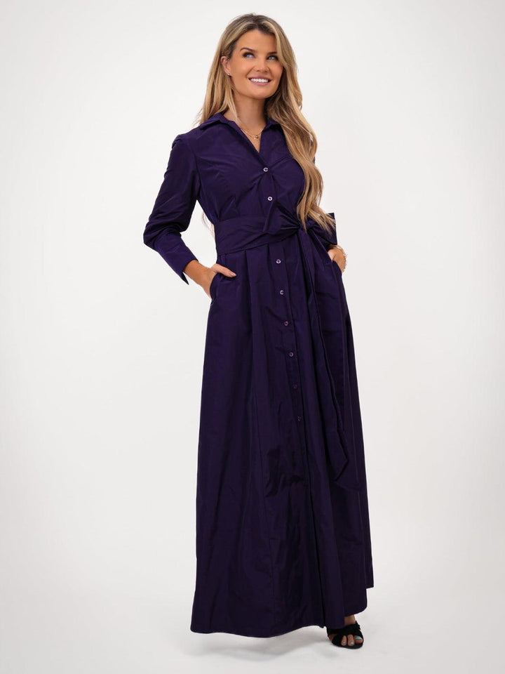 Woman wearing a long purple dress on a white background