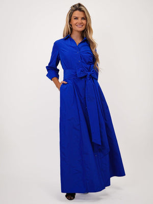 Woman wearing a blue dress with a belt on a white background