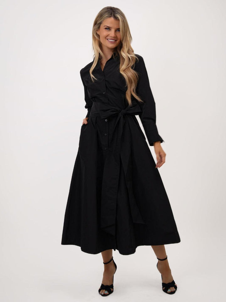 Woman wearing a black dress with a belt on a white background