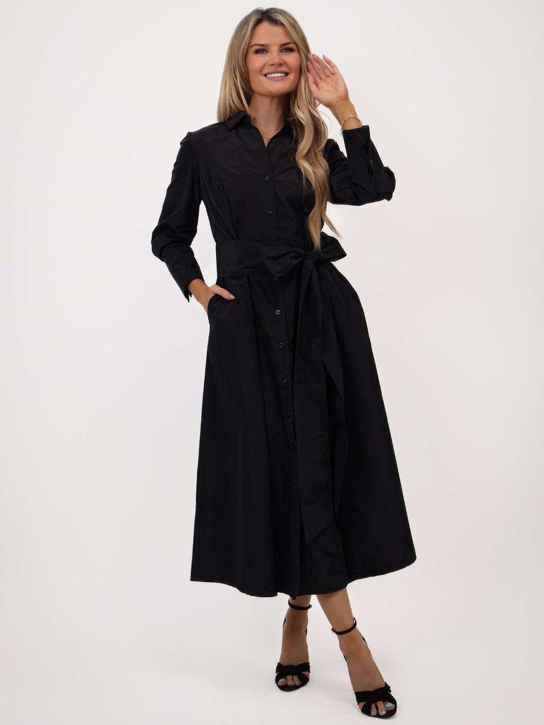 Woman wearing a black dress with a belt on a white background