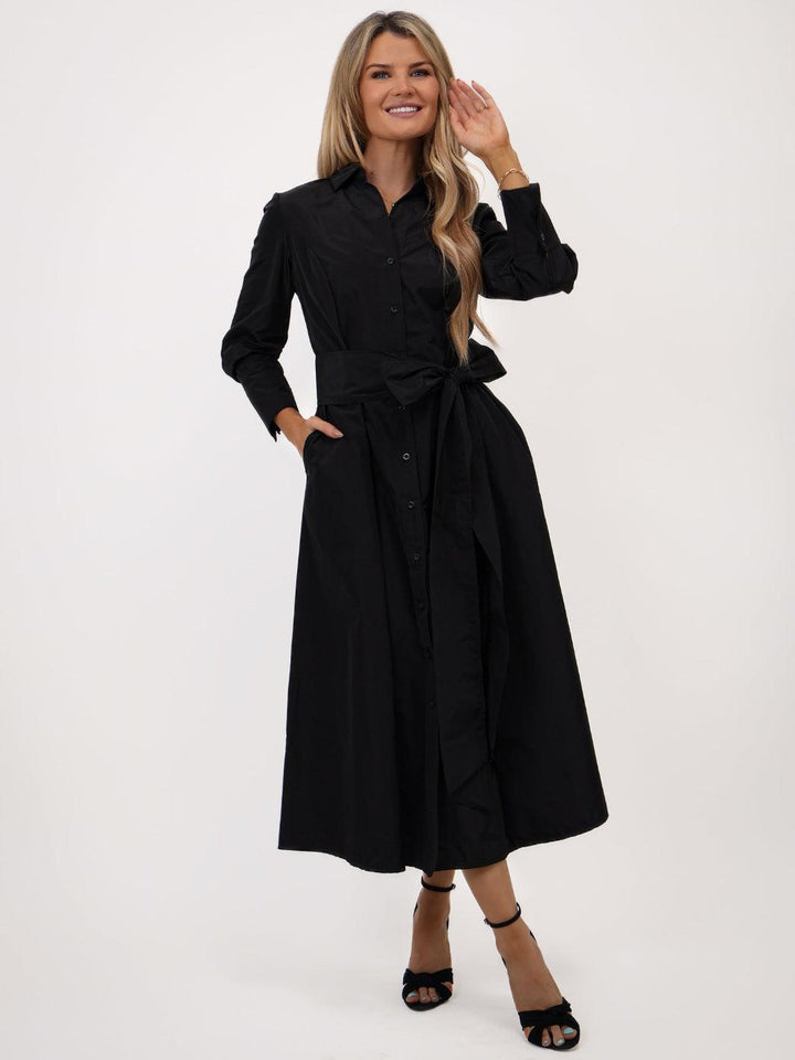 Woman wearing a black dress with a belt on a white background