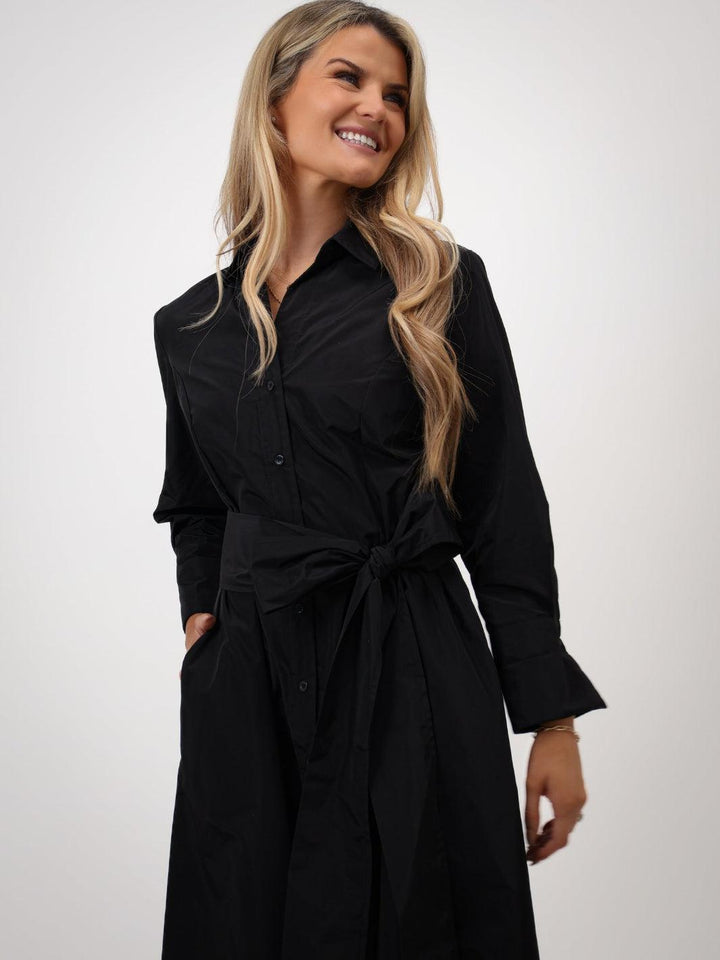 Woman wearing a black trench coat on a white background