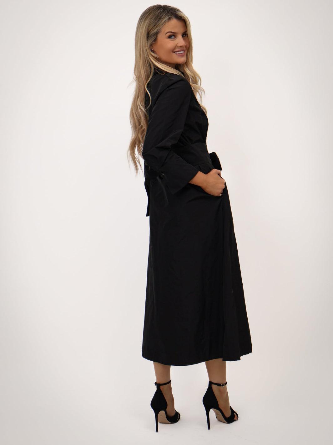 Woman wearing a black coat and skirt set on a white background