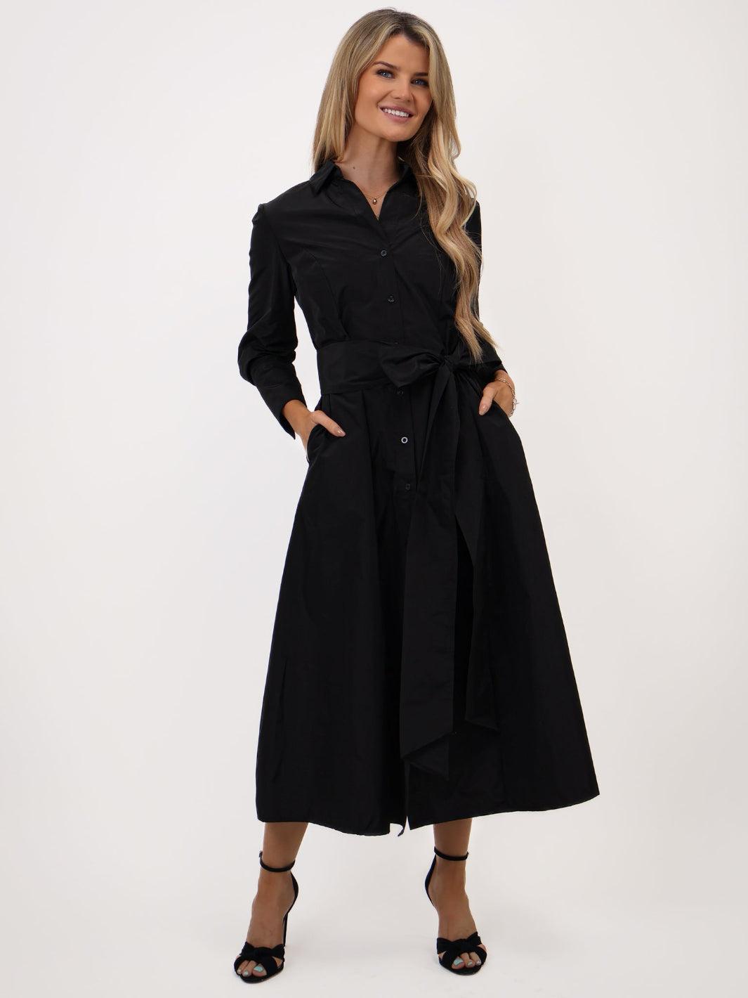 Woman wearing a black dress with a belt on a white background