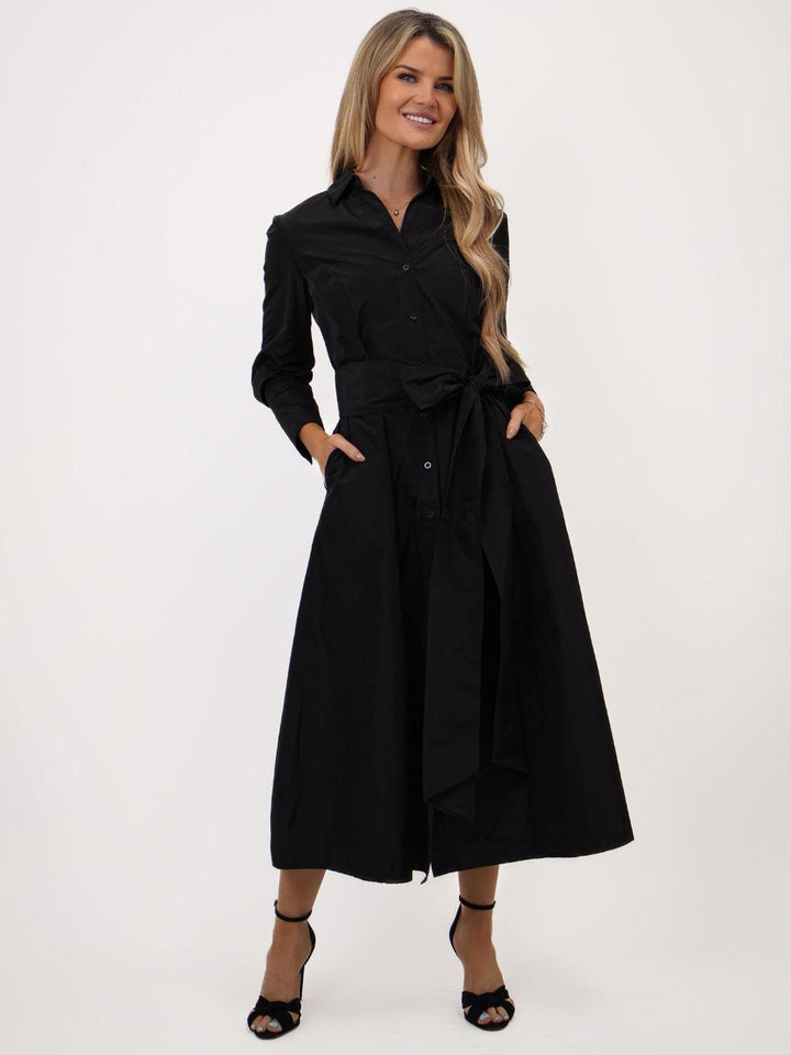 Woman wearing a black dress with a belt on a white background