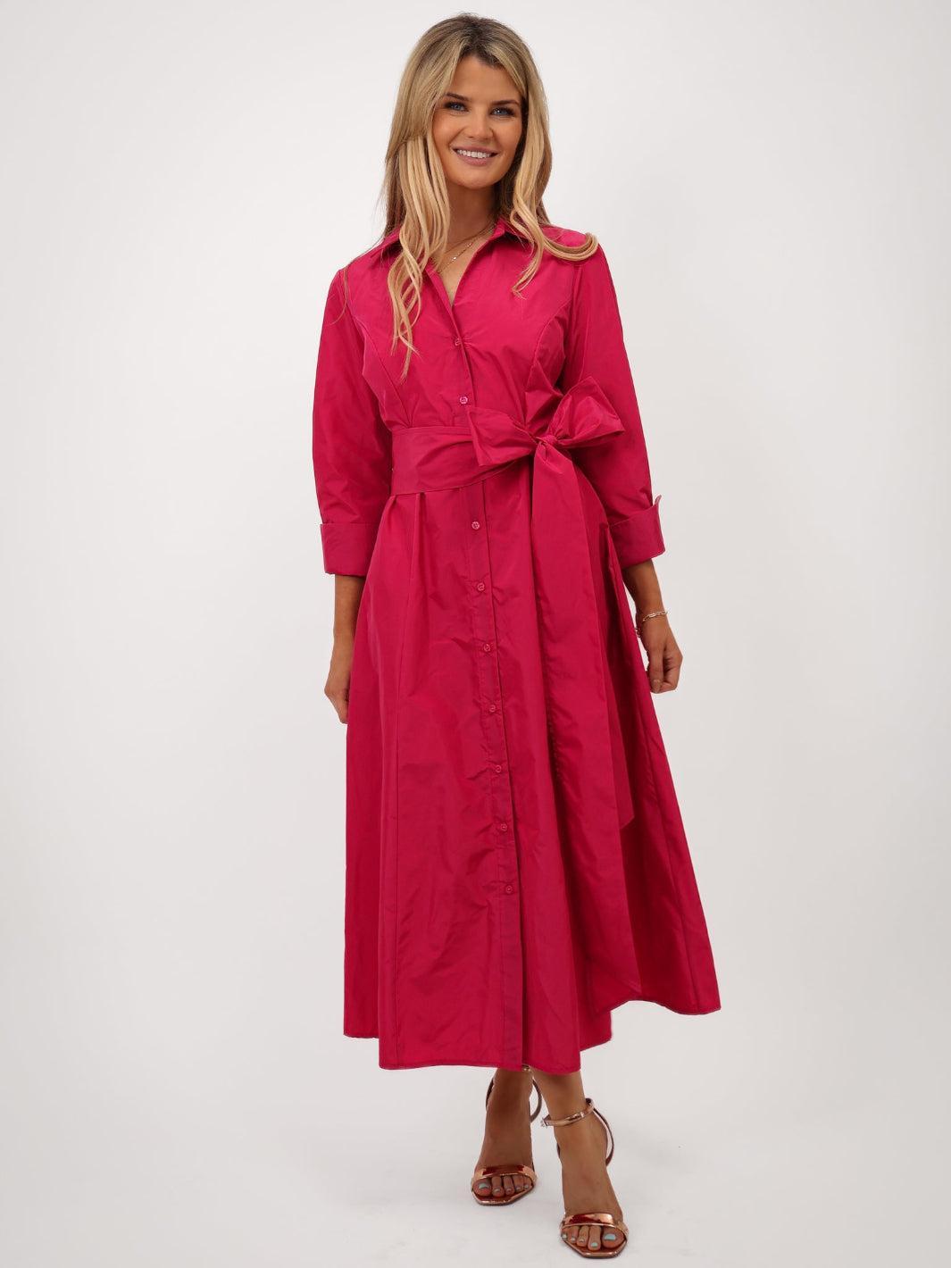 Woman wearing a red dress with a belt on a white background