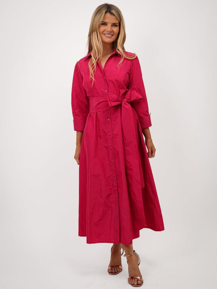 Woman wearing a red dress with a belt on a white background