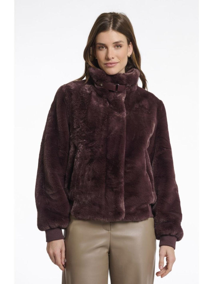 Woman wearing a brown fur jacket on a white background