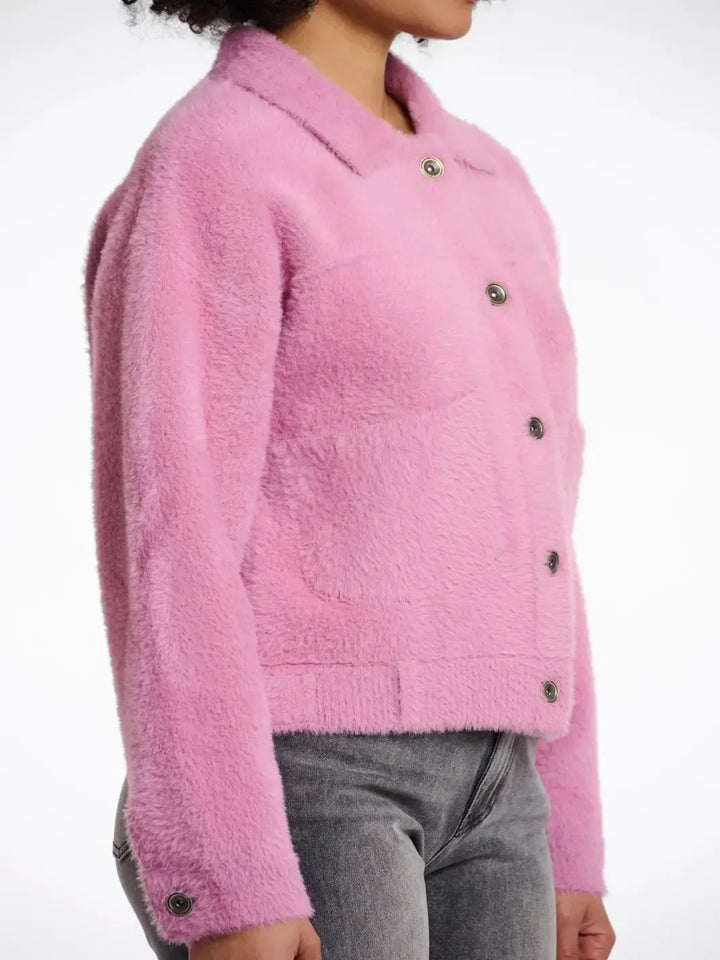 Pink textured jacket worn by a person on a white background