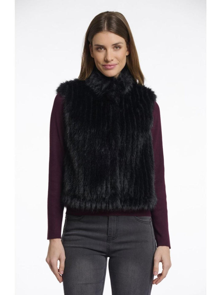 Woman wearing a black fur vest on a white background