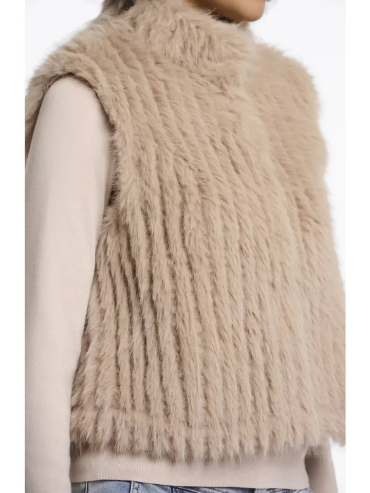 Beige fluffy vest worn by a person on a white background