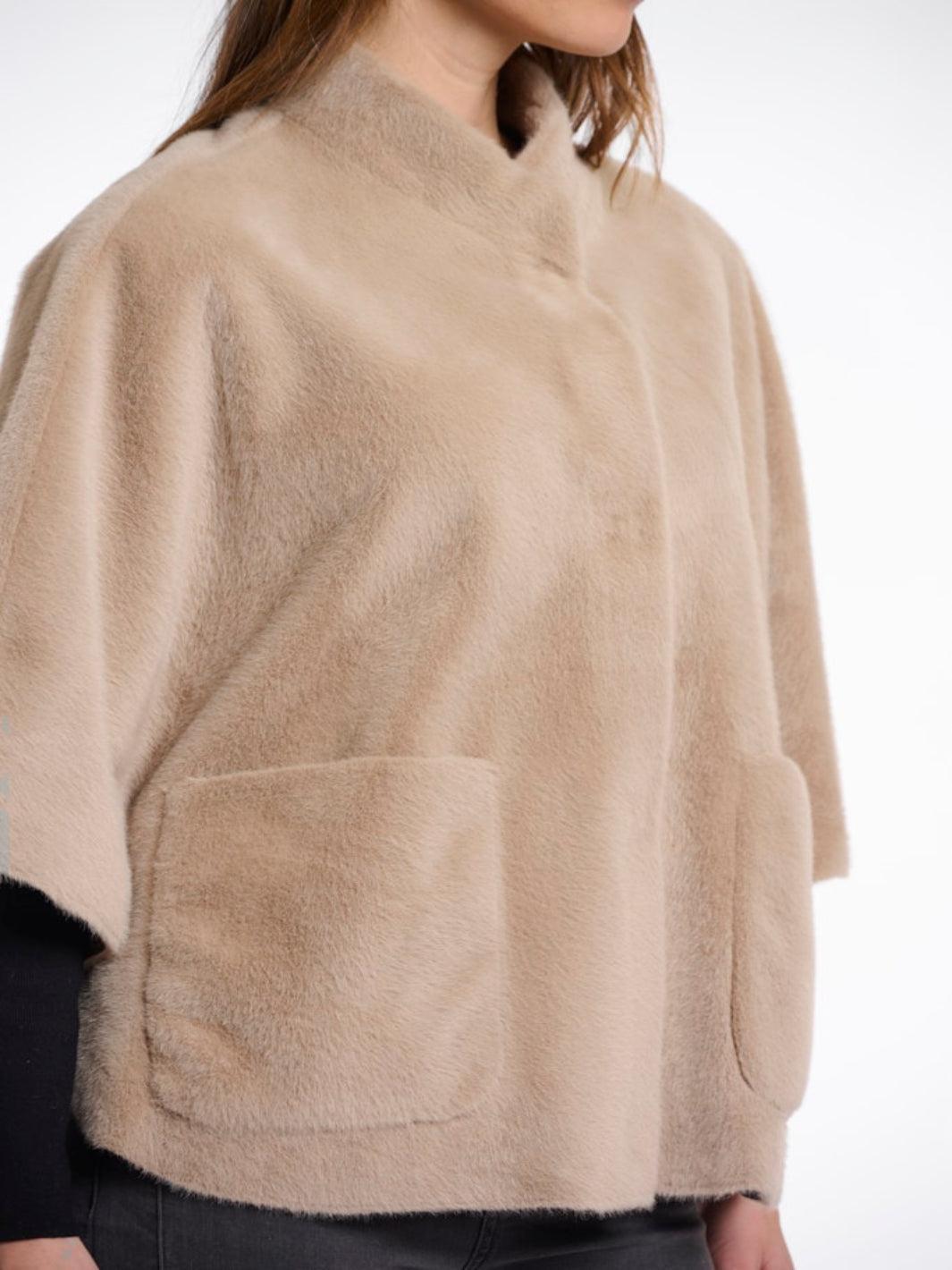 Beige fleece poncho worn by a person on a white background
